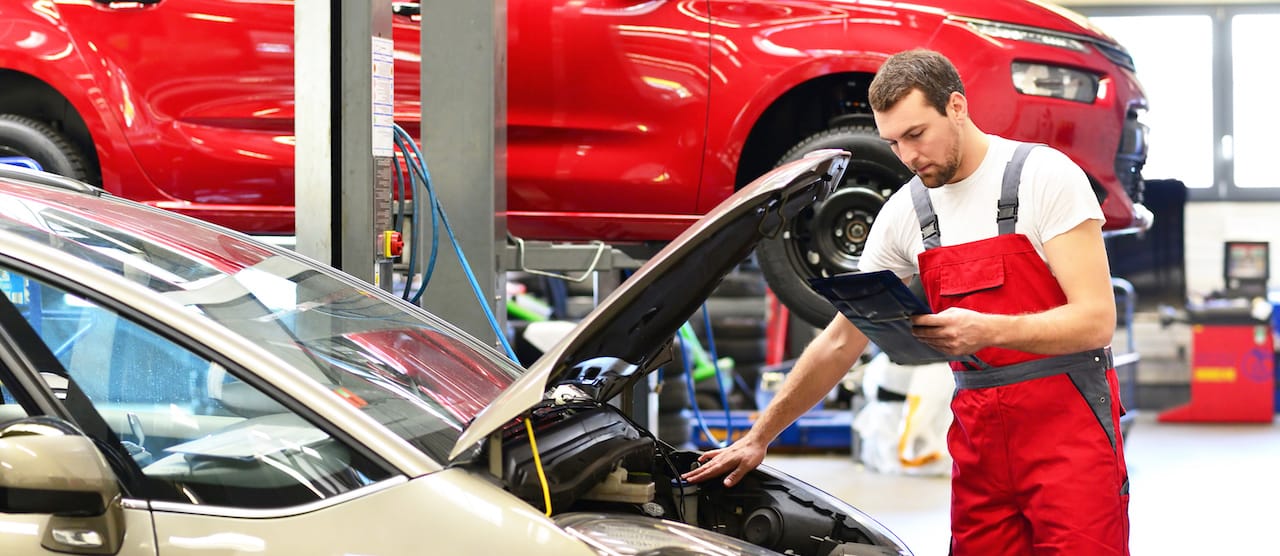 A person checking the car for repairs